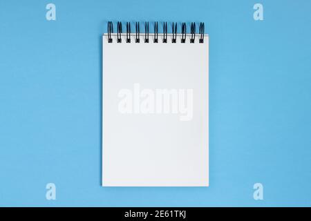 Open notepad on a blue background, overhead view with copy space Stock Photo