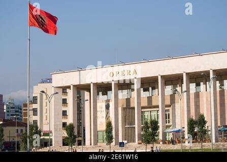 Tirana, Albania - July 26, 2012: the National Theater of Opera and Ballet and the red Flag with double-head eagle in Skanderbeg Square of Tirana; many Stock Photo