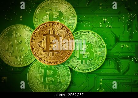 Golden Bitcoins on a mainboard. Top view. Stock Photo