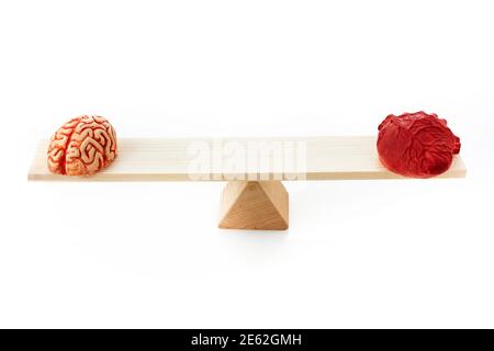 Brain and heart on scale balance on white background Stock Photo