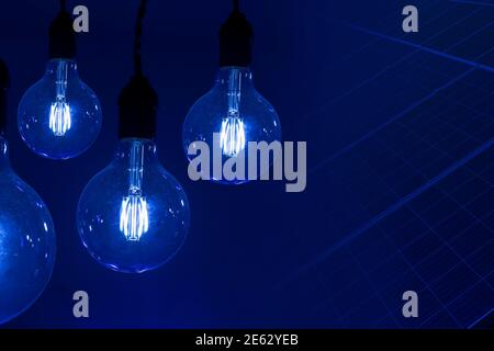 various vintage antique electric lamps against dark background and solar energy collector plates - concept of ideas Stock Photo