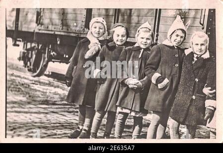 GERMANY - CIRCA 1960s: The retro photo shows the group of small girls outsides. Fife little girl-children in winter time. 1960s Stock Photo