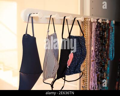 Four different anti-covid fabric face masks washable hanging in closet. Stock Photo