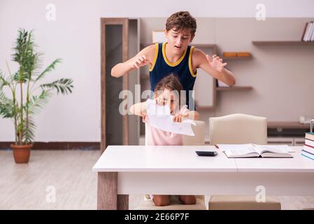 Teenager and his small sister staying at home during pandemic Stock Photo