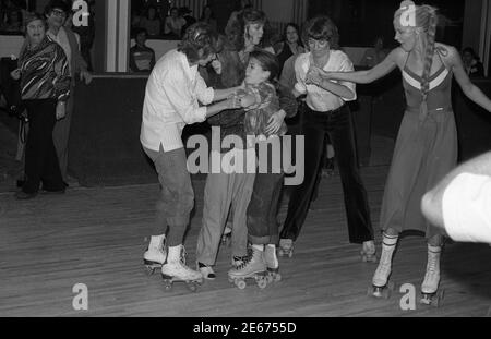 Celebrity roller skating mishap at Flippers Roller Boogie Palace in West Hollywood as young actress collides with Pam Dawber and Stock Photo