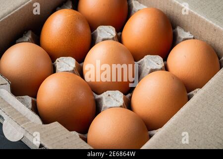 Raw chicken eggs in egg box set, on black background Stock Photo