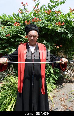 Senior Kuban Cossack holding a saber in the garden Stock Photo