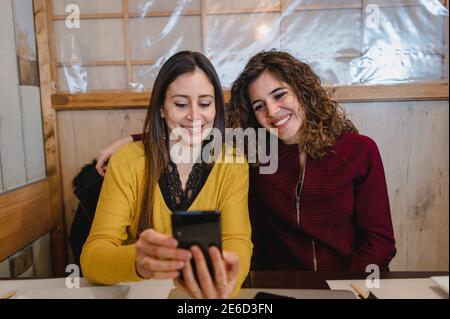 Smiling Hispanic women having a video call over a phone Stock Photo