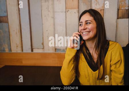 Hispanic woman having a conversation with someone using her mobile phone Stock Photo