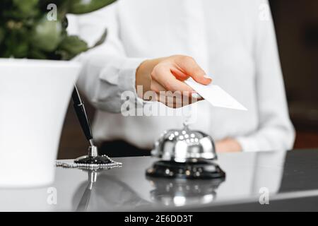 Close up of woman hotel receptionist giving you door key Stock Photo