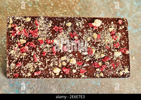 Chocolate bar with nuts and berries on concrete background Stock Photo