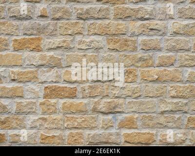 Wall with a rough textured cladding of beige red rectangular tiles Stock Photo