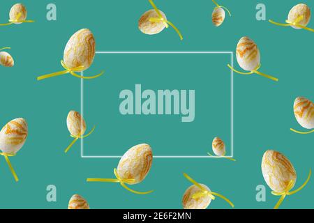 Spring pattern with flying yellow eggs on turquoise background. Zero gravity concept. Hello spring, frame for text. Stock Photo
