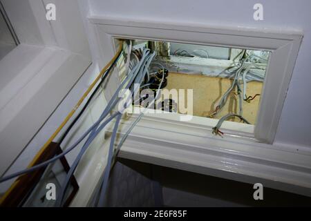 refitting and testing a new fuse board and safety checking the wiring in a small loft space. Stock Photo