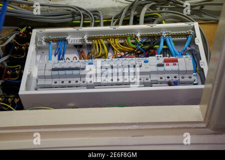Electrician refitting and testing a new fuse board and safety checking wiring Stock Photo