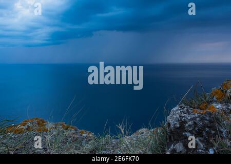 Storm clouds over the sea are black and blue. A hurricane is coming, a downpour. Natural sinister background. Storm warning. Weather disasters. The se Stock Photo