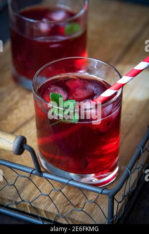 Cherry cocktail with mint on a wooden tray. Top view. Stock Photo