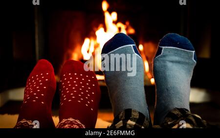 Feet in woolen socks in front of a warm fireplace on a cold winters evening.  Stock Photo