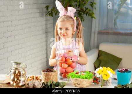 Happy little girl with bunny ears getting ready for Easter party Stock Photo