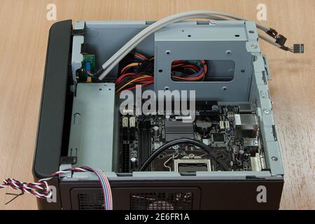 Components and case for assembly of personal computer are lying on wooden desk. Stock Photo