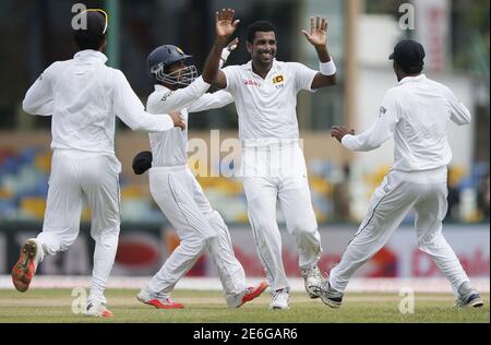 Sri Lanka's Dhammika Prasad (2nd R) celebrates with his teammates Kaushal Silva (2nd L), Tharindu Kaushal (R) and Dinesh Chandimal (L) after taking the wicket of India's Lokesh Rahul (not pictured) during the first day of their third and final test cricket match against India in Colombo, August 28, 2015. REUTERS/Dinuka Liyanawatte