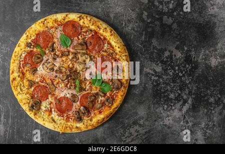 Whole neapolitan pizza served on dark board Stock Photo