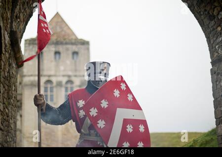 Medieval English knight stands at castle entrance Stock Photo