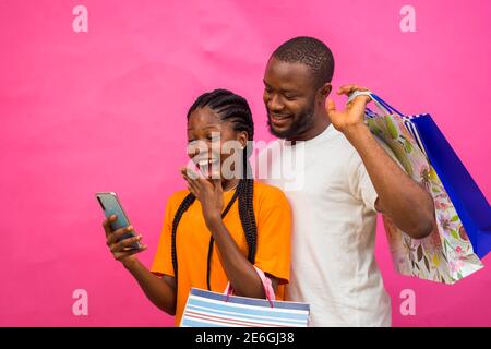 young black beautiful lady and a handsome guy checking something on a smartphone Stock Photo
