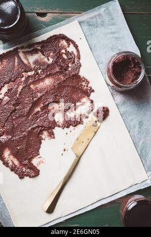 Black olive tapenade savory pastry making process on a green rustic wooden table. Stock Photo