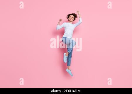 Full size photo of cheerful girl win jump raise fists wear pullover gumshoes isolated pink color background Stock Photo