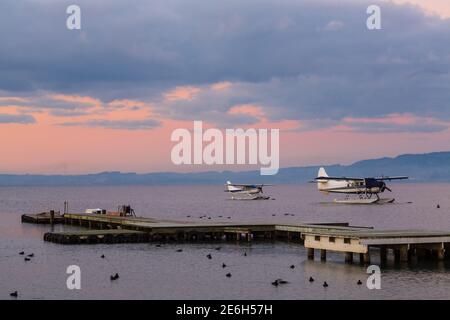 Two floatplanes on a lake under a purple sunset sky Stock Photo