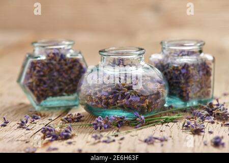 Dried lavender in glass jars on wooden background Stock Photo