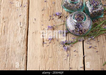 Dried lavender in glass jars on wooden background Stock Photo