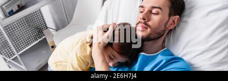 diseased father embracing daughter while lying in hospital, banner Stock Photo