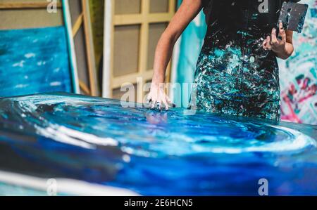 Senior woman painting inside her atelier studio at home - Artist female person having fun doing artistic works - Art activities and mature people conc Stock Photo