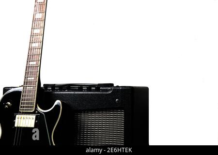 Black electric guitar with guitar amplifier on a white background Stock Photo