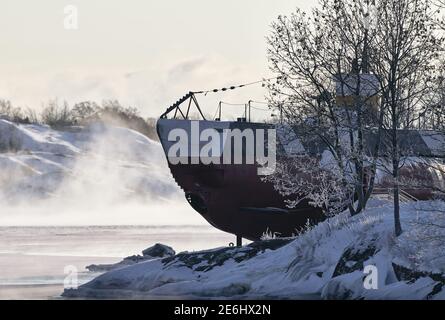 Helsinki, Finland - January 15, 2021: A Finnish WW II era museum submarine Vesikko in the Suomenlinna fortress island with frozen trees and snowy arch Stock Photo