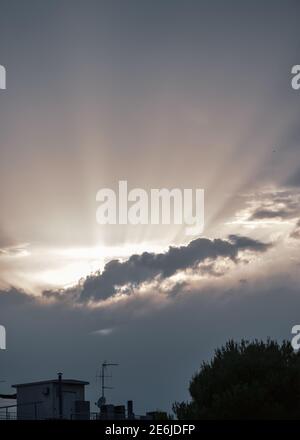 rays of sunshine coming out from behind the clouds after a storm. Stock Photo