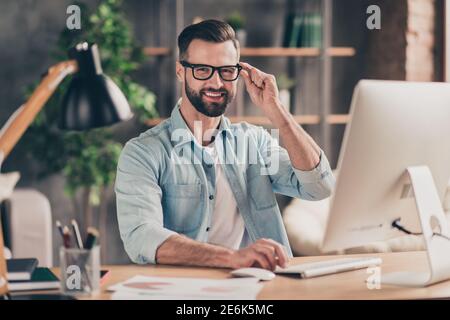 Photo portrait of guy holding glasses working on pc at table in modern industrial office indoors Stock Photo