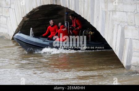Paris fire brigade divers on a rescue boat patrol on the flooding Seine River past the Pont de l'Archeveche bridge, near Notre-Dame Cathedral, in Paris, June 4, 2016, after days of almost non-stop rain caused flooding in the country.  REUTERS/Christian Hartmann