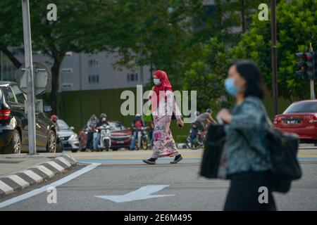 Kuala Lumpur, Malaysia. 29th Jan, 2021. People wearing face masks walk on a street in Kuala Lumpur, Malaysia, Jan. 29, 2021. Malaysia recorded 5,725 confirmed cases of COVID-19 in its highest daily spike since the outbreak of the coronavirus in the Asian country, bringing its total tally to 203,933, the Health Ministry said on Friday. Credit: Chong Voon Chung/Xinhua/Alamy Live News Stock Photo