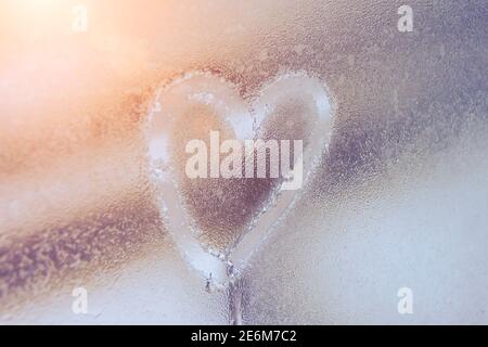 Heart on misted glass. Heart on a window background. Heart symbol of love drawn on the glass Stock Photo