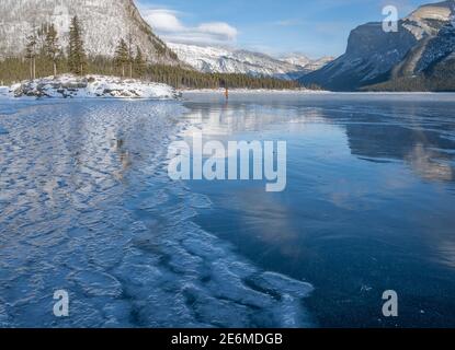 Reflections in frozen Lake Minnewanka in Banff National Park, Alberta, Canada Stock Photo