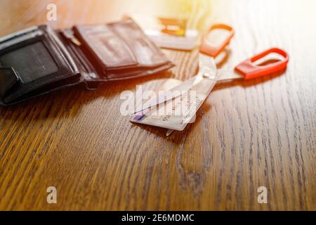 Irreversible destruction of a deactivated payment card by cutting with scissors Stock Photo