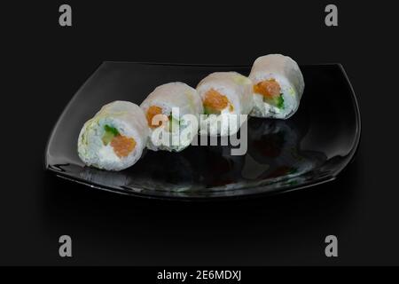 freshly made Japanese sushi rolls served on a black stone slab Stock Photo