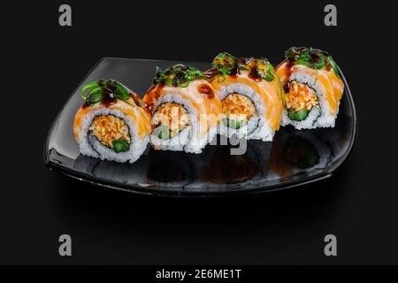 freshly made Japanese sushi rolls served on a black stone slab Stock Photo