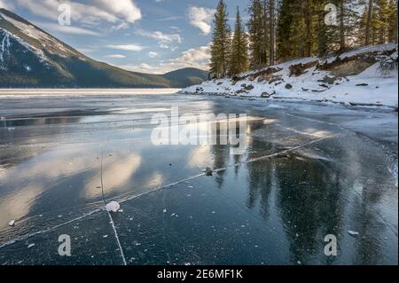 Reflections in frozen Lake Minnewanka in Banff National Park, Alberta, Canada Stock Photo