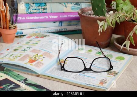 Gardening books. UK. Gardeners glasses on a stack of her gardening books. Stock Photo