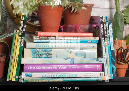 Gardening books. UK. Gardeners glasses on a stack of her gardening books. Stock Photo