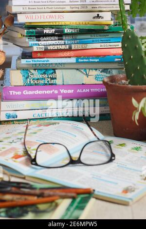 Gardening books. UK. Gardeners glasses on a stack of her gardening books. Stock Photo